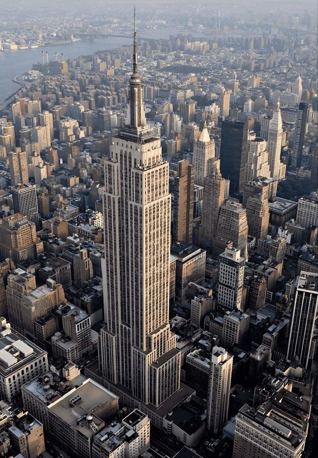 From an elevated perspective, the grandiose Empire State Building looms prominently amidst the urban landscape, evoking a sense of wonder and admiration.
