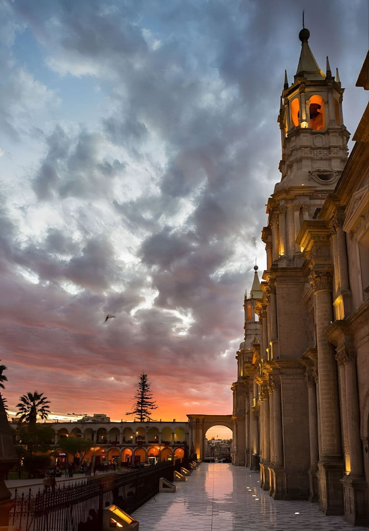 The sun sets, illuminating Arequipa Cathedral with a radiant light, creating a stunning display of colors in the sky.