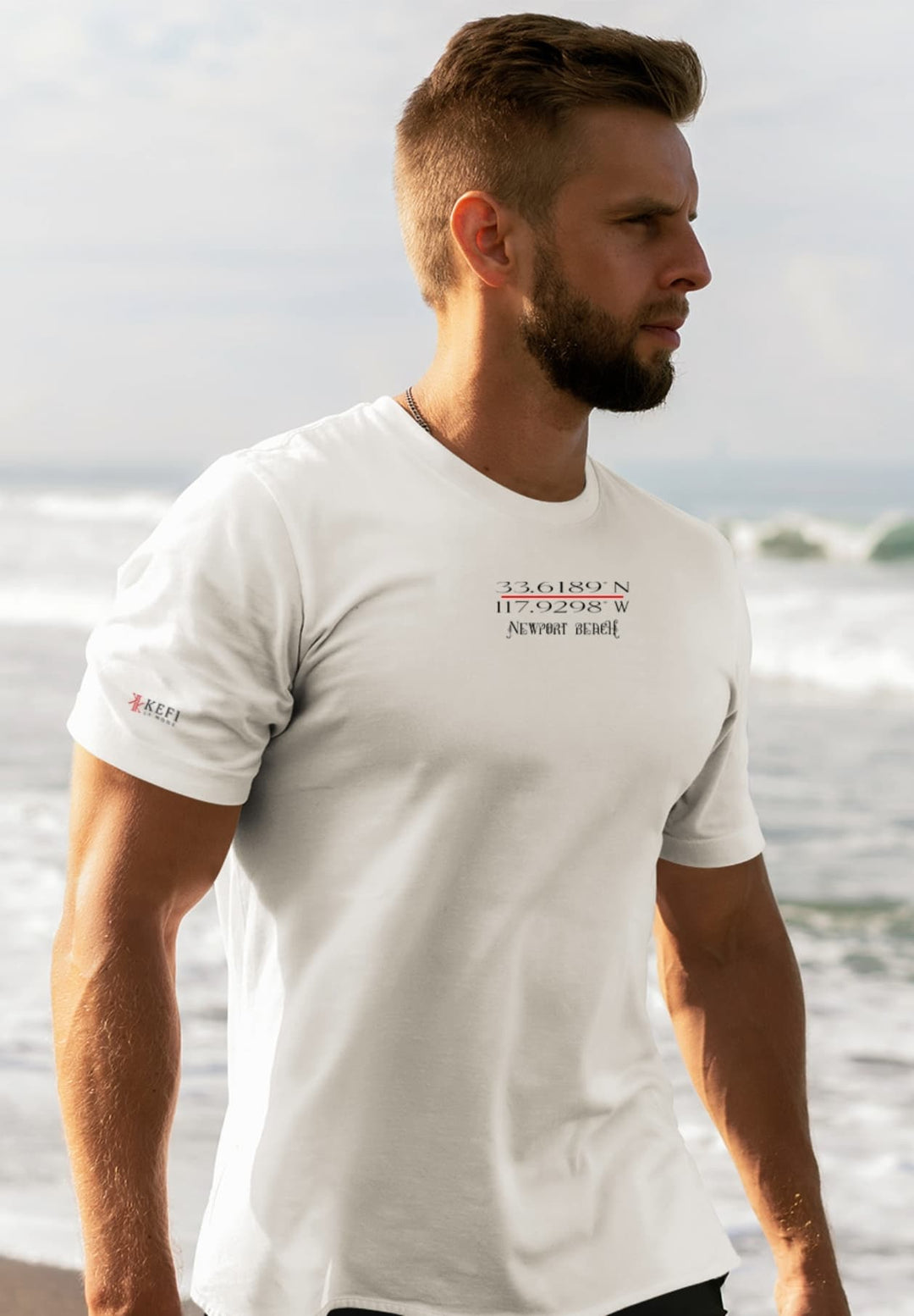 With each breath of sea air, the bearded man in a white tee feels a timeless connection to nature's embrace.