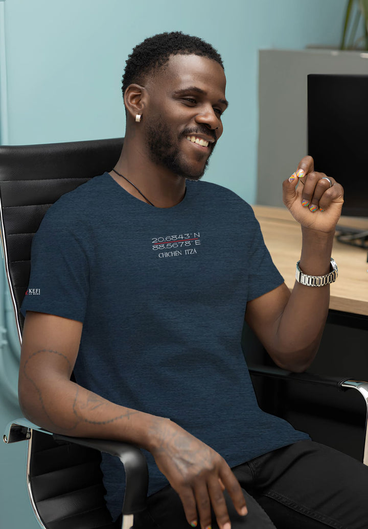 The man, dressed in a round-necked blue t-shirt attire and sporting a beard, embraces commitment and creativity in his professional setting.