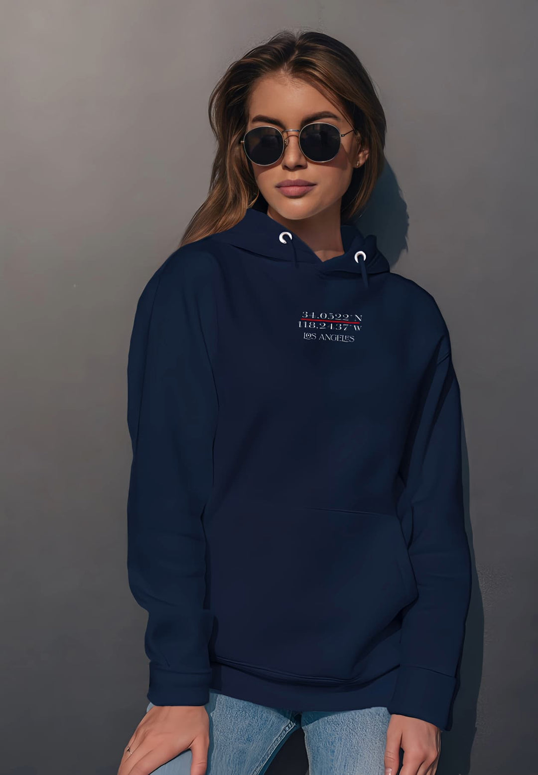 With her stylish sunglasses, the young woman exudes an air of contemporary confidence and casual elegance in her blue hoodie.
