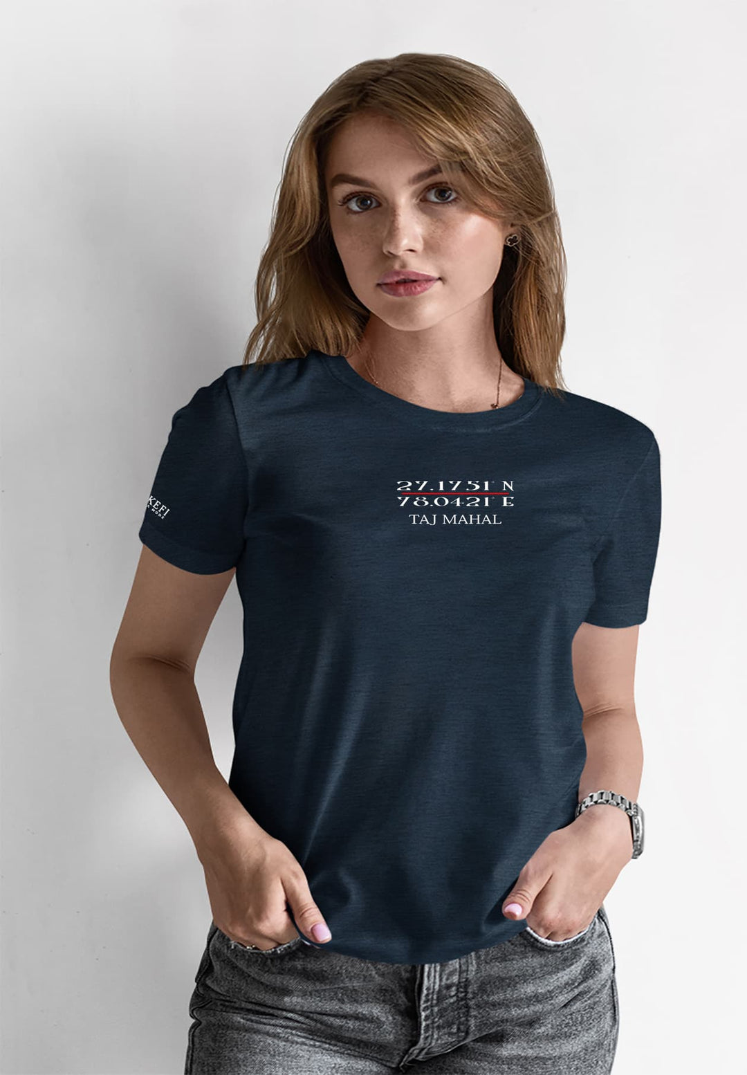 The woman stands with hands on hips, wearing a blue T-shirt that captures her having a moment of beauty.
