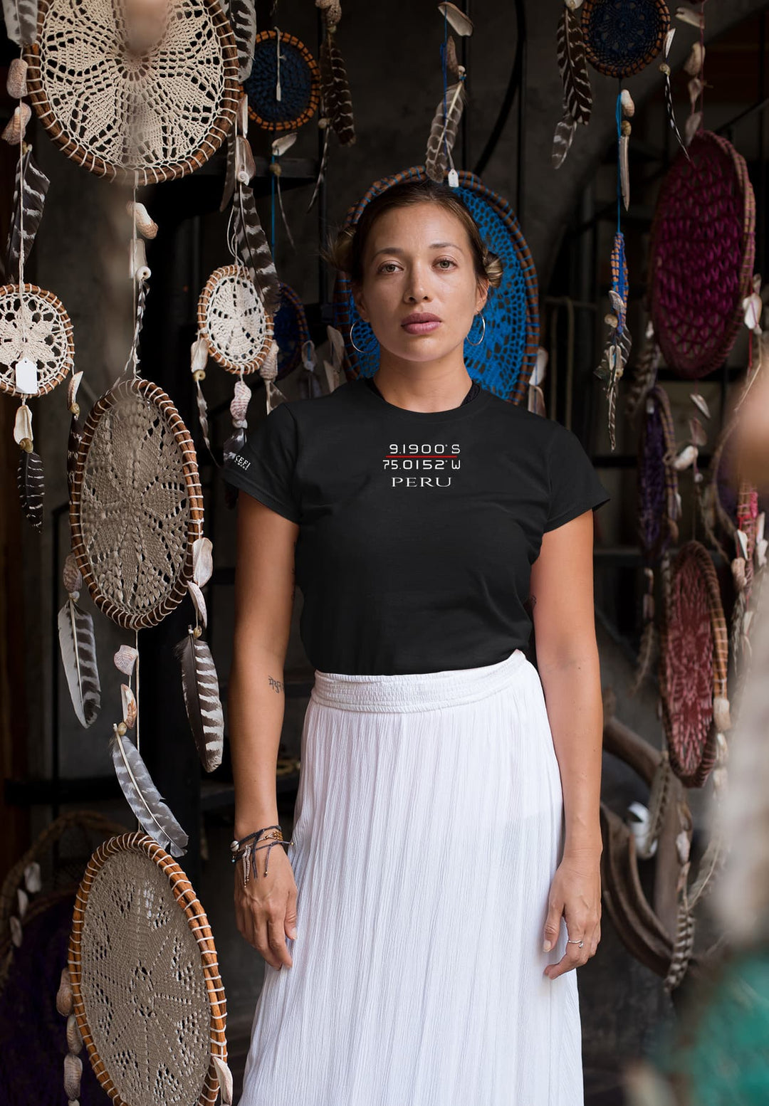In a realm of dream catchers, she stands adorned in a black tee and white skirt, a vision blending simplicity with ethereal charm.