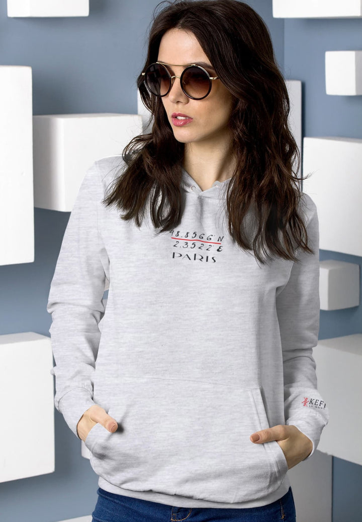 The woman's choice of a gray pullover hoodie, paired with stylish sunglasses, is a capture of comfort and modern chic.