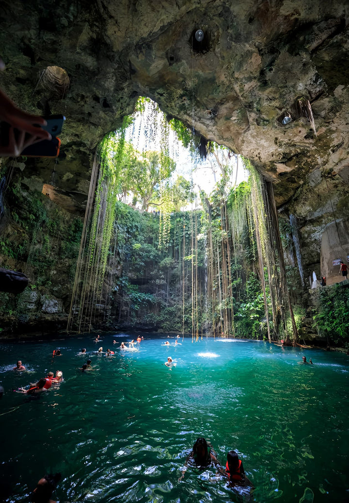 People swimming in Ik-Kil cenote near Chichen Itza, Mexico.