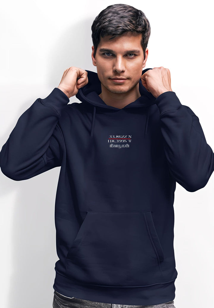 A young man poses in a navy blue hoodie with Hermosa Beach's GPS coordinates.