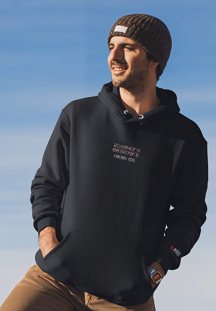 A male with a cheery demeanor, dressed in a black hoodie logo and a beanie.