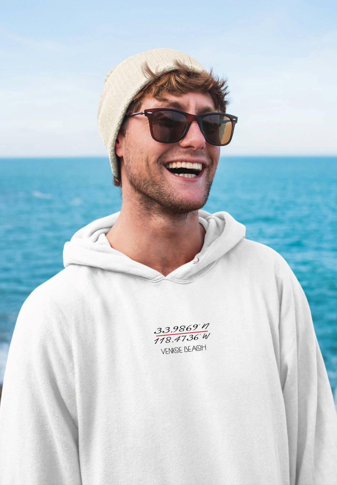 With his white hoodie and mysterious sunglasses, the beach of the city becomes the young man's personal moment.