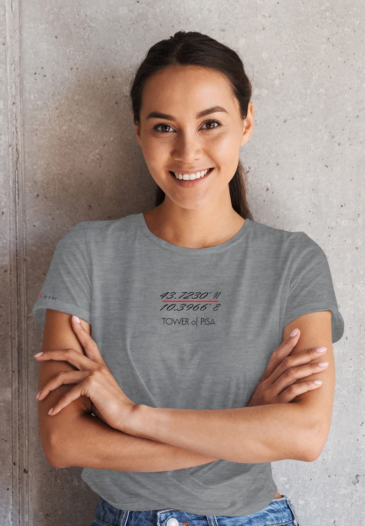  In casual grace, a woman stands with arms crossed, in a gray T-shirt and jeans, exuding a relaxed yet confident demeanor.