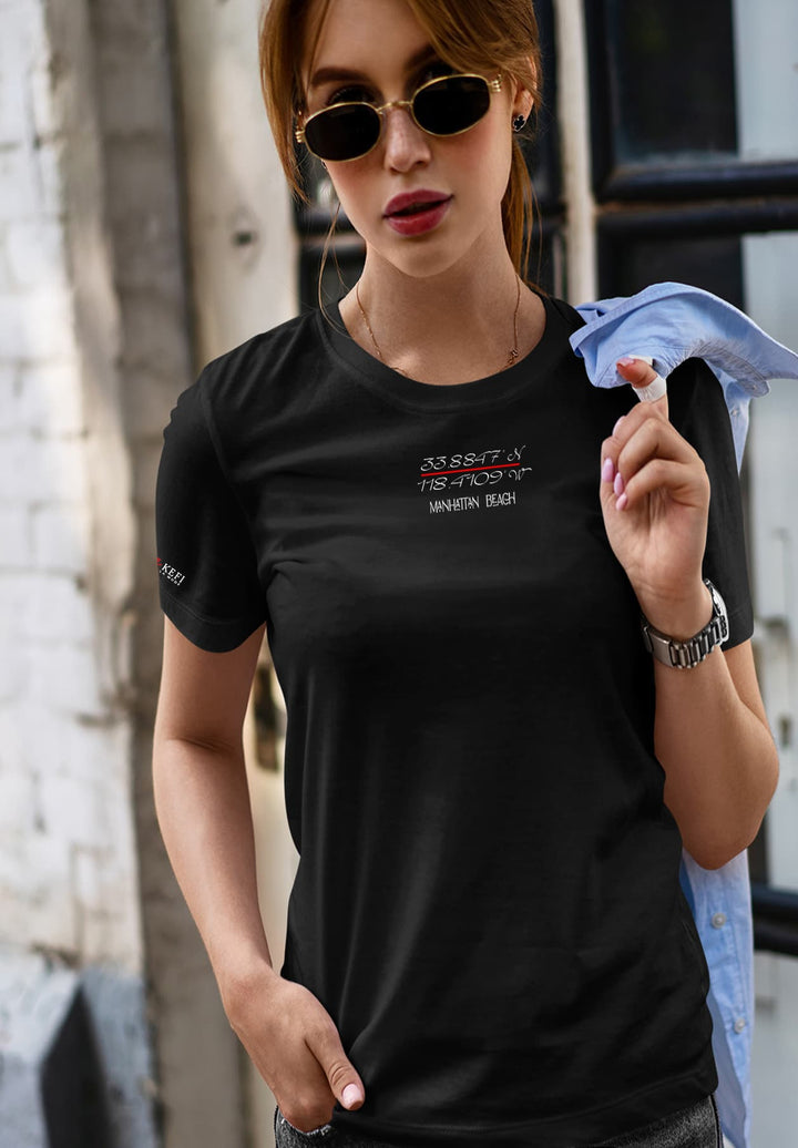 Embracing the urban rhythm, a lady strides confidently in a sleek black t-shirt and chic sunglasses, embodying a fusion of style and self-assurance.