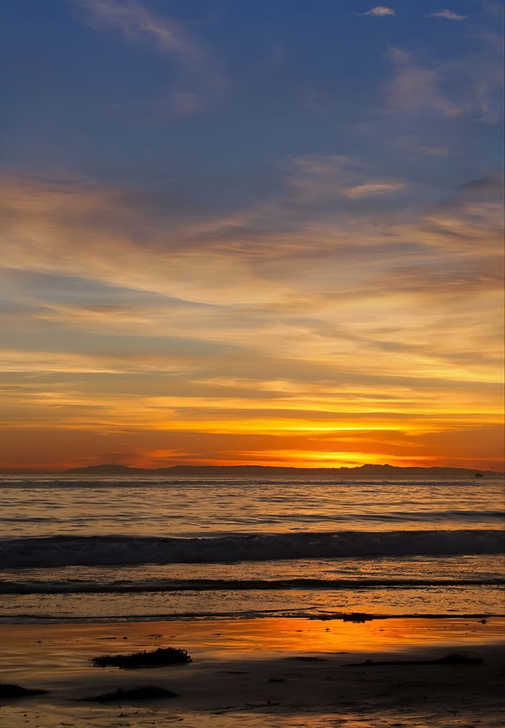 Experience the breathtaking serenity as the sun gracefully bids farewell over the majestic ocean in the heart of Laguna Beach, CA.