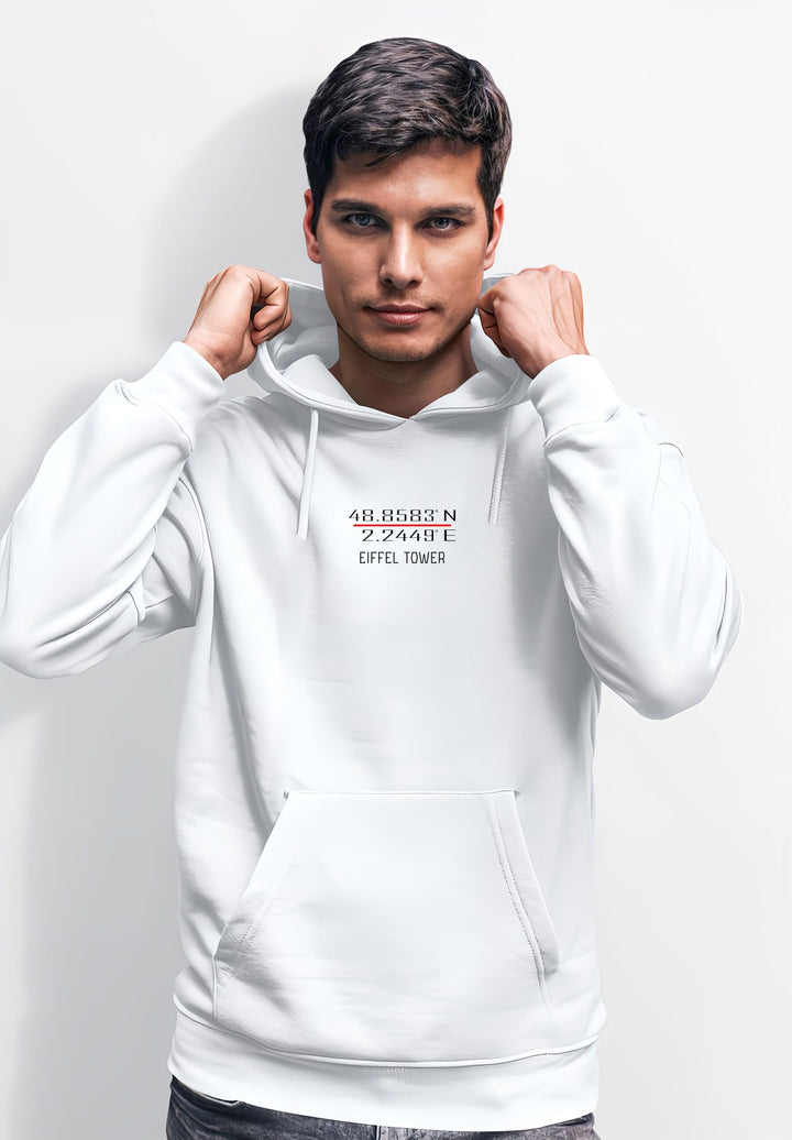 A photograph is being taken of a man wearing a white hoodie while he strikes a pose.