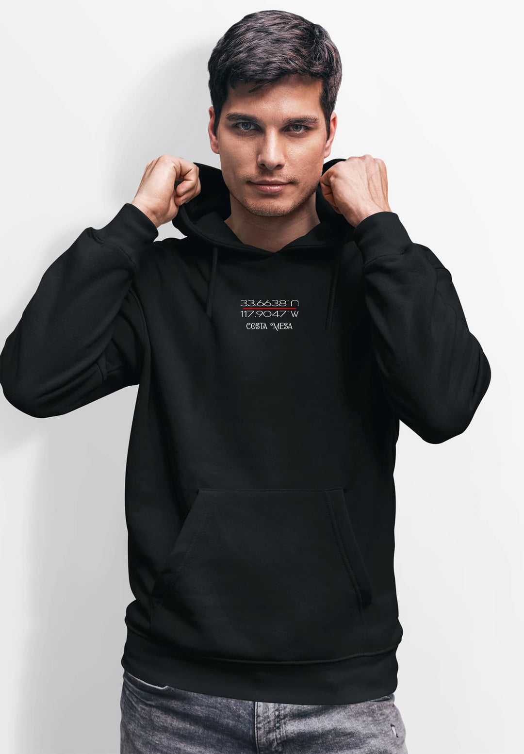A male wearing a black hoodie and standing still for the camera while posing for a picture.