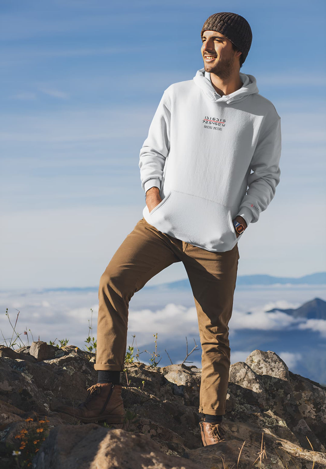 A single individual wearing a Machu Picchu white hoodie and standing atop a mountain.