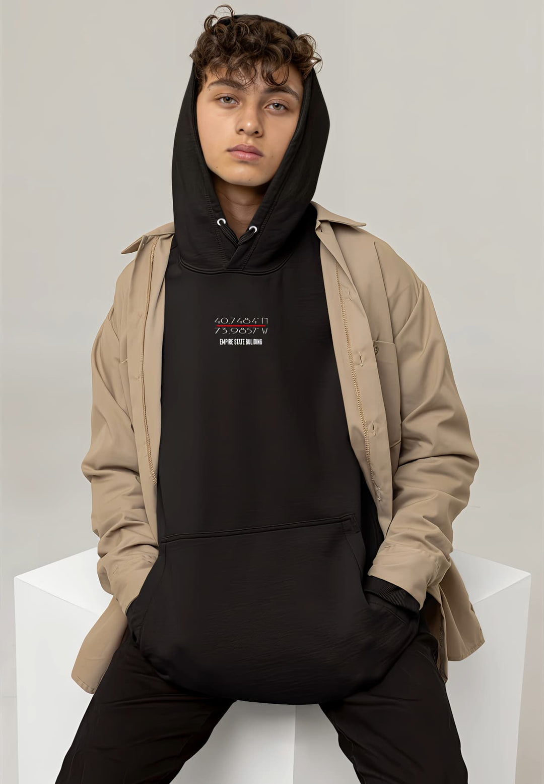 In the ever-evolving world of style, the young man's choice of a black hoodie and jacket becomes a defining moment of casual urban chic.