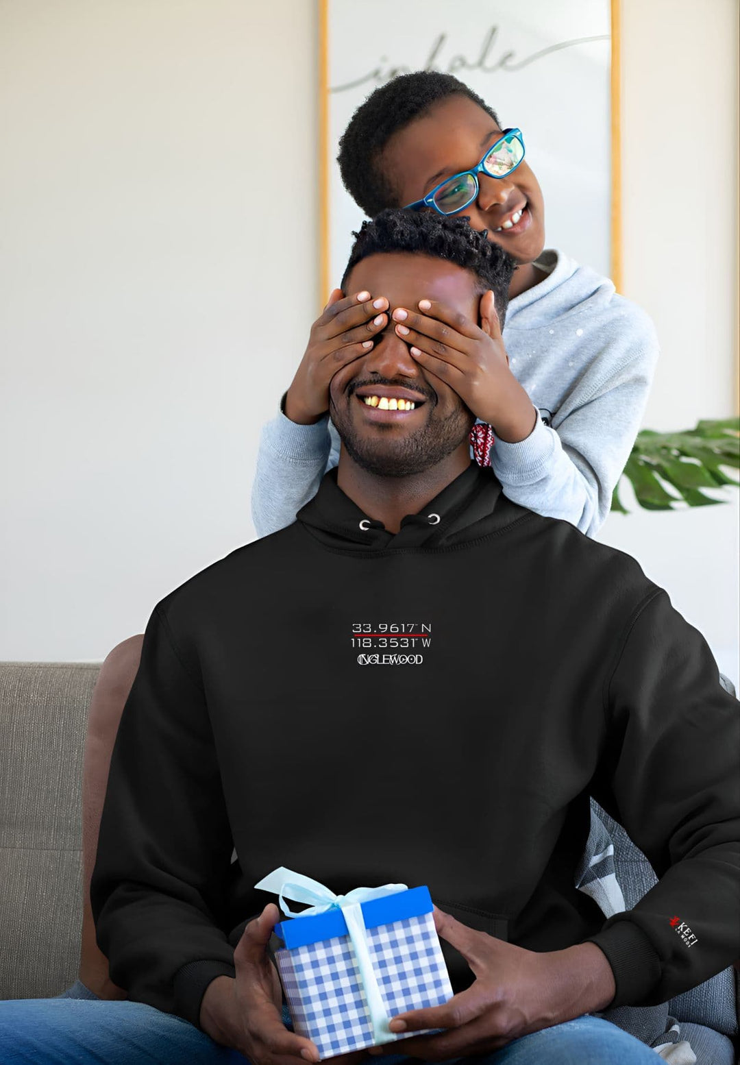 In his black hoodie, the man shares a heartfelt gift, creating precious moments and memories with his beloved son.