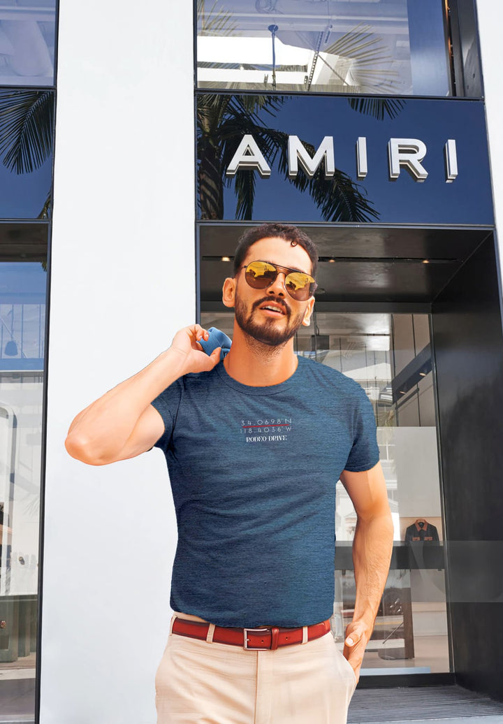 In the backdrop of the building, he stands, his blue tee and tan pants a canvas of silent emotions.