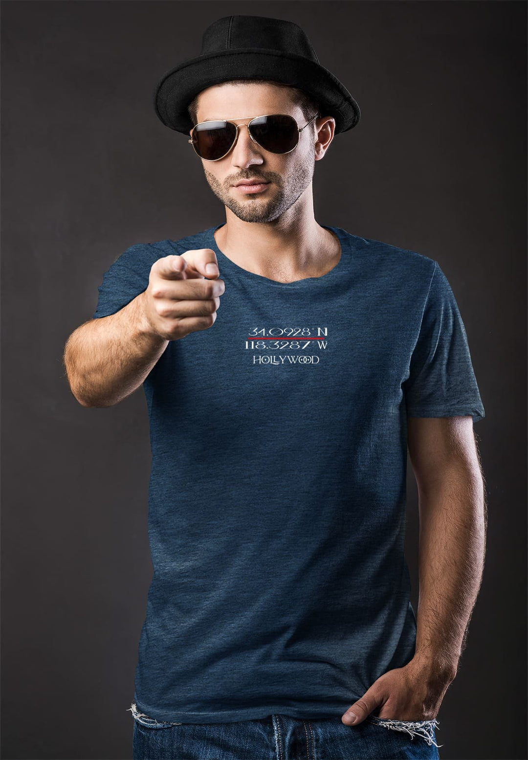 In the blue embrace of his tee, the man points at the camera, sharing a moment where emotions converge and connect.