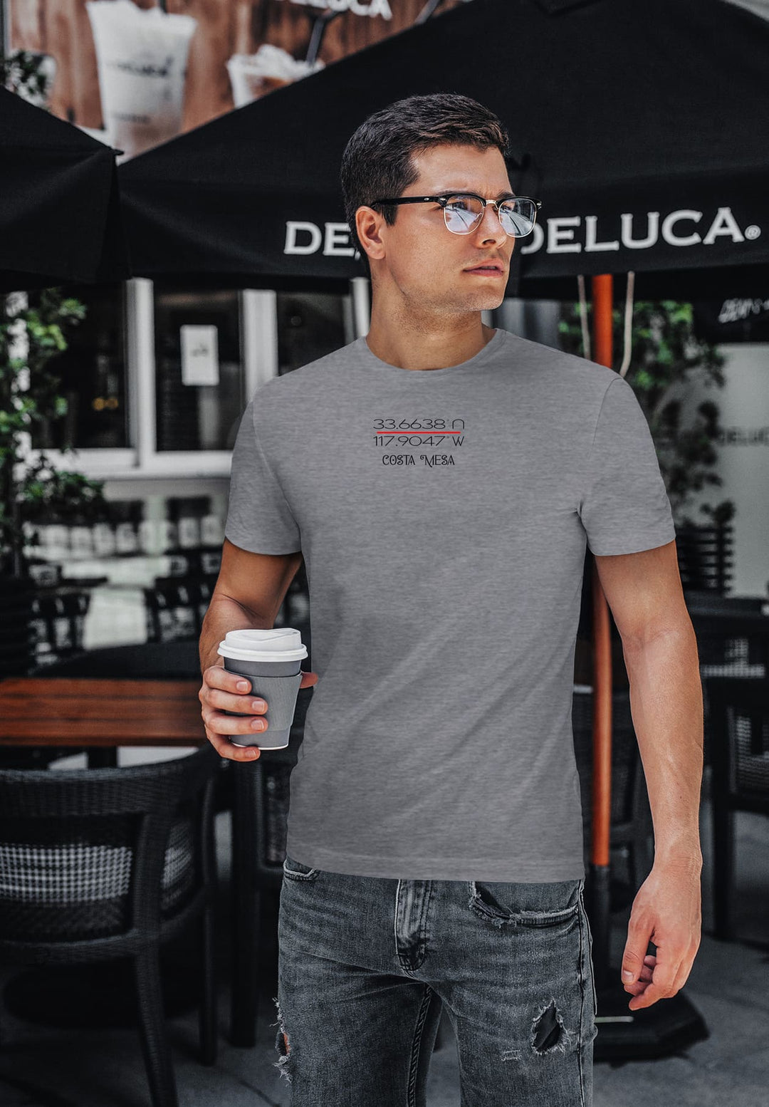 Savoring coffee, he stood in a gray t-shirt, glasses framing thoughtful eyes, a moment wrapped in quiet reflection.