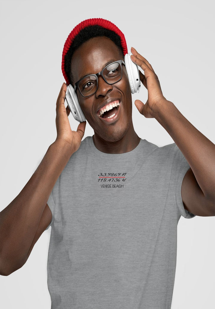 His glasses and red knitted hat hold memories of cozy warmth, his gray tee resonating with musical moments.