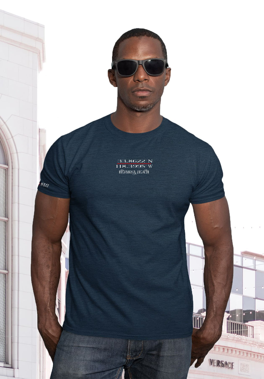 Posing in blue tee, sunglasses shading emotions, hands in pockets echo a silent narrative—the man's portrait, a symphony of style and depth.