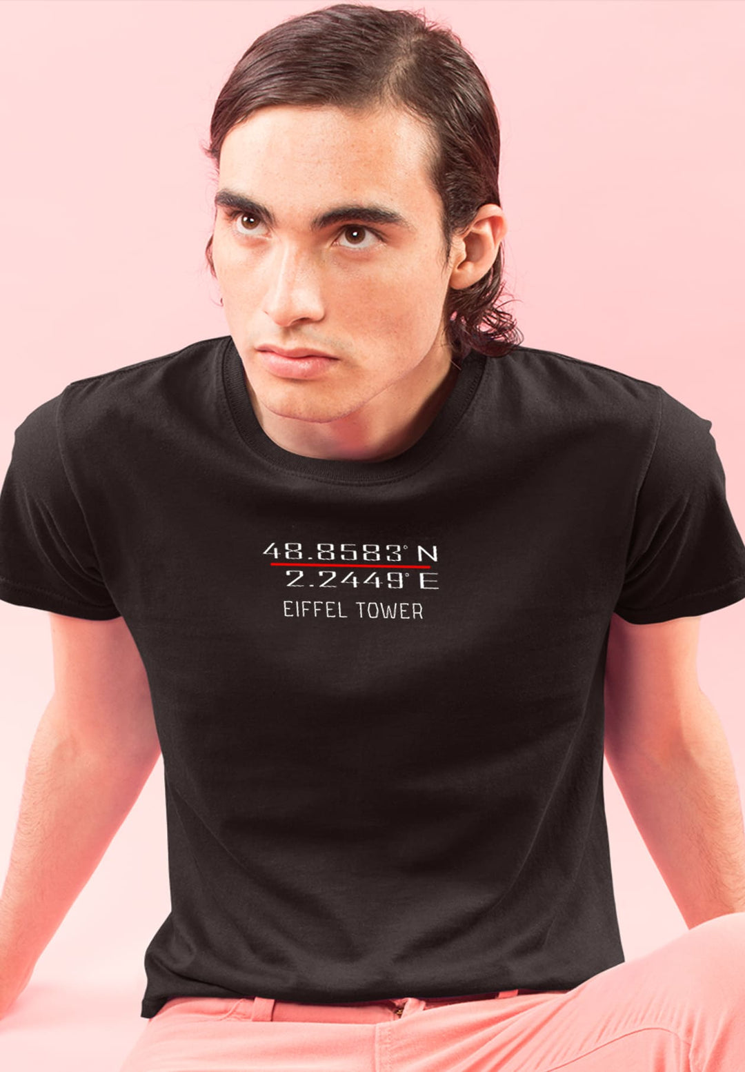 Basking in serenity, a man finds comfort on the ground, his black tee echoing simplicity, a poetic pause in life's rush.