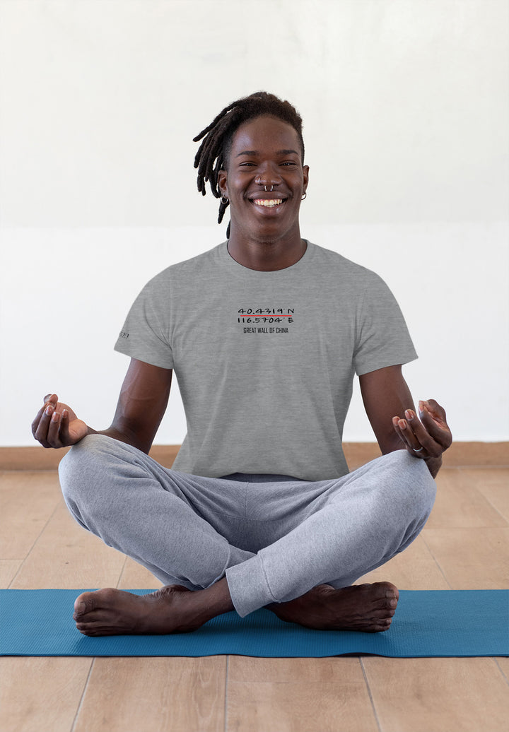 On the yoga mat, the man in a gray tee sits, a serene smile unveiling the peaceful emotions within.