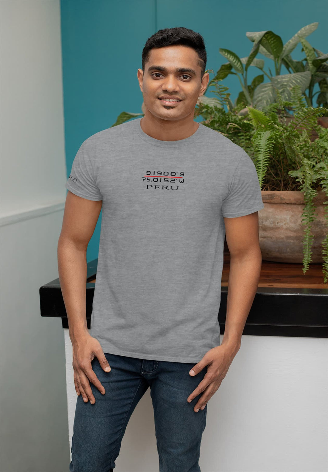 Amidst the leaves, he stands, his Peru gray tee a reminder of distant lands, grounding him in moments of tranquility.