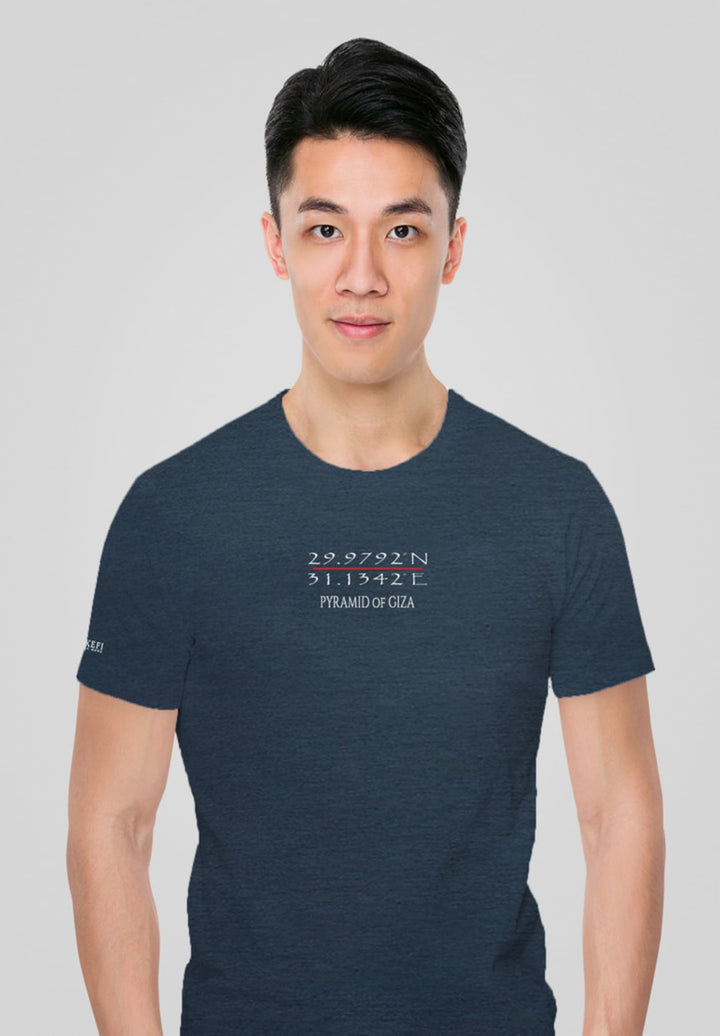 Hands in pockets, the man in the blue tee stands, a silent portrait of contemplation, emotions swirling in solitude.