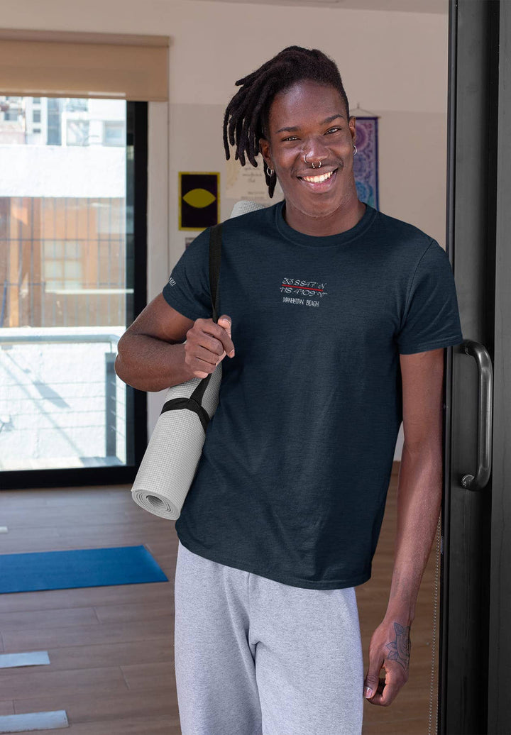 His dreadlocks sway gently as he holds the water bottle in a blue tee, a moment of replenishment and reflection.