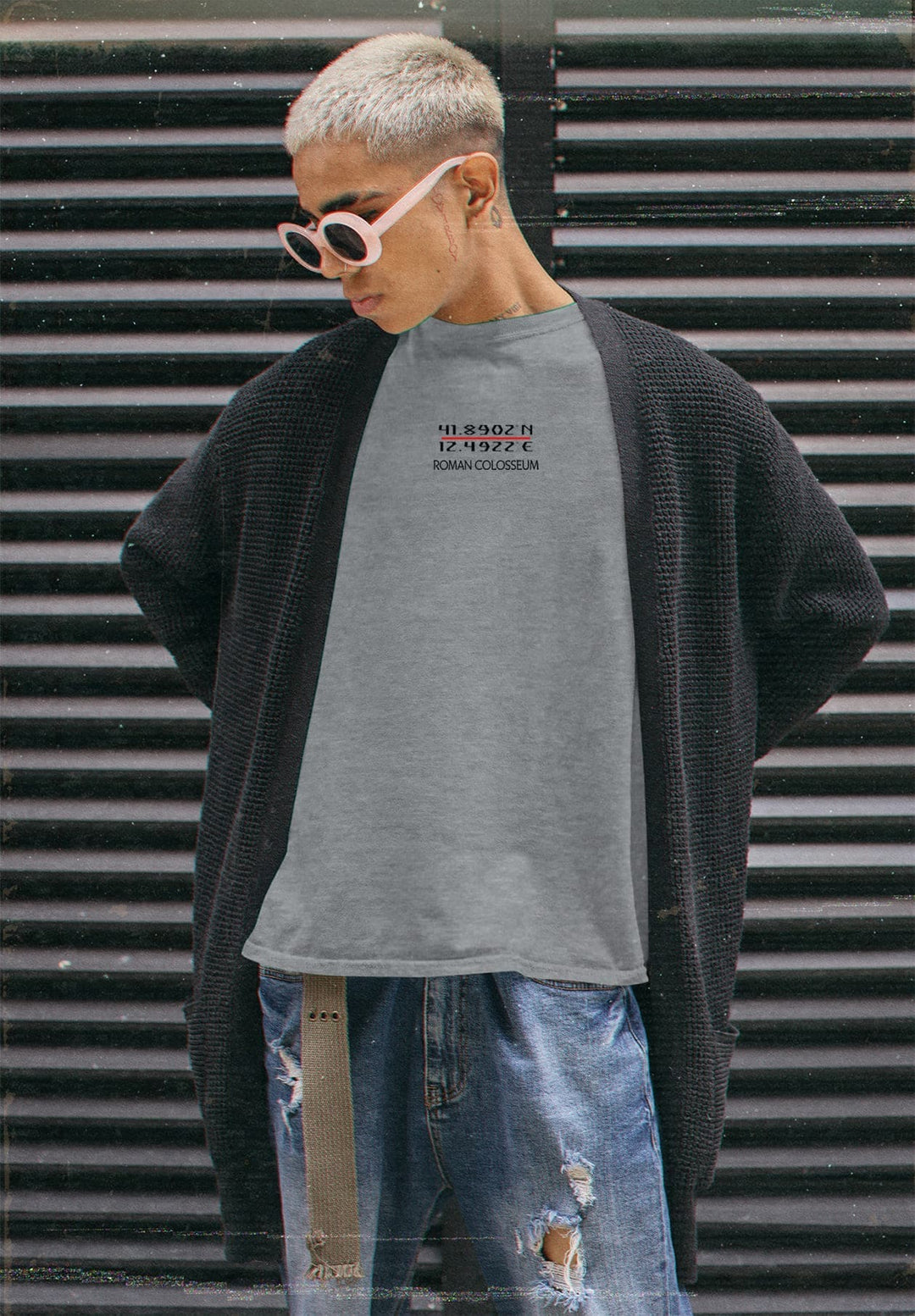 Amidst the world's hustle, he stands in gray tee and ripped jeans, each tear a chapter, each crease a memory.