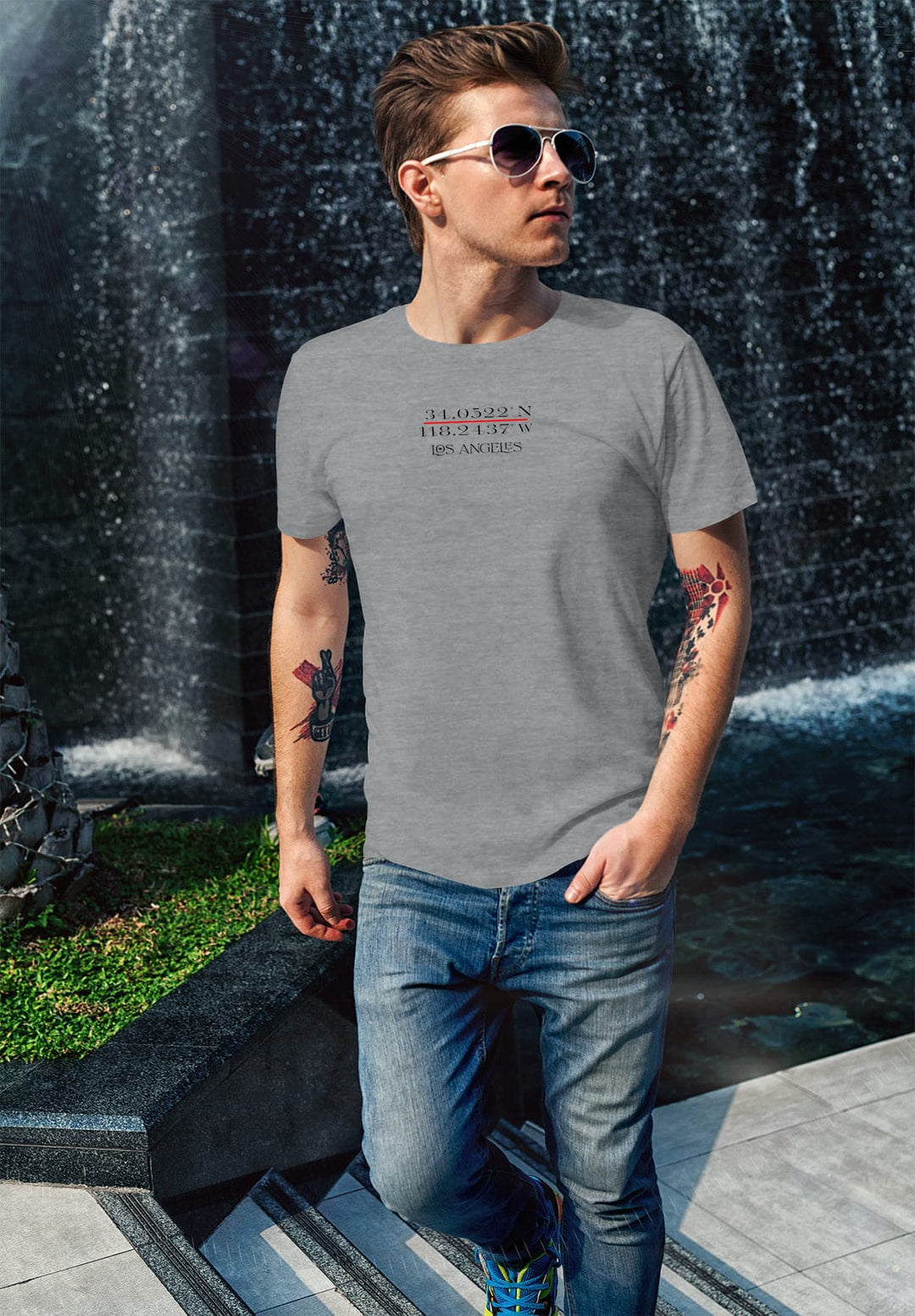 Walking by the waterfall, his gray tee and sunglasses reflect his inner peace, a serene journey amidst nature's wonder.