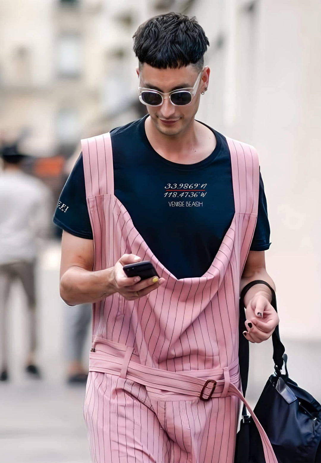 Walking in pink pinstripe overalls and a black tee, he embodies moments of confidence and individuality, memories cherished.