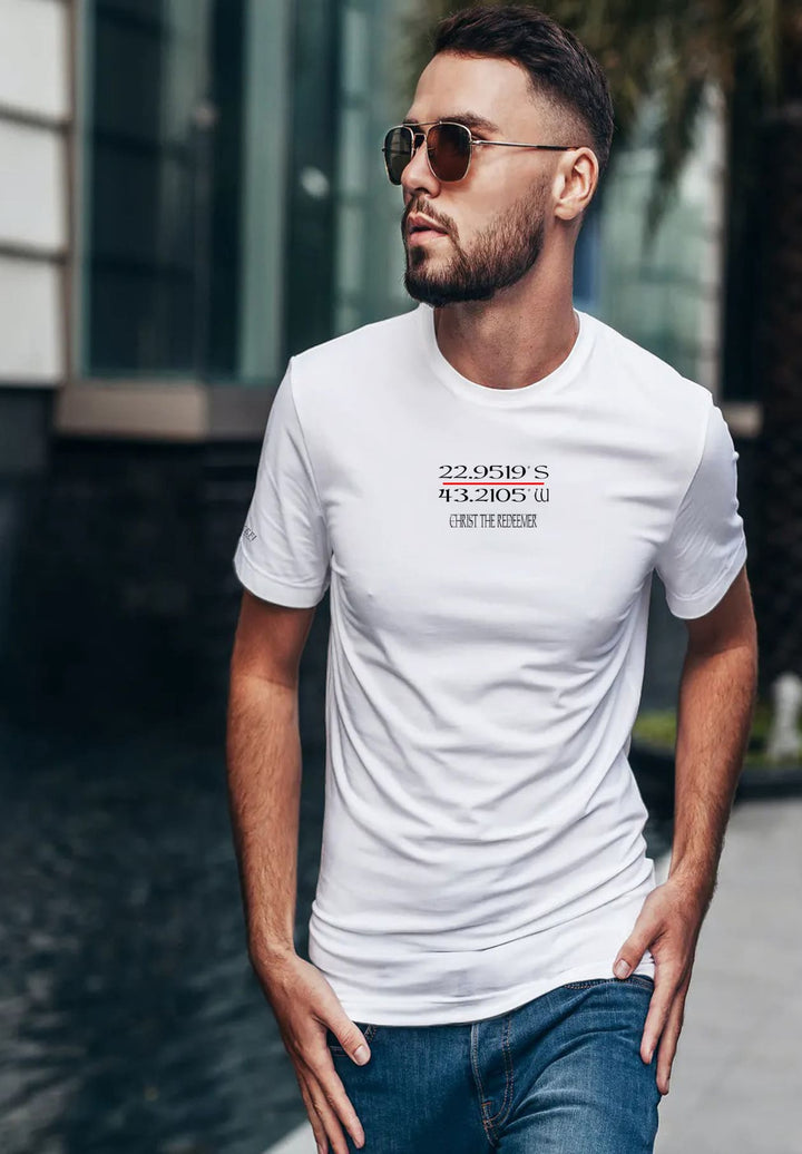 In the radiant embrace of sunlight, a man in a white tee strolls, sunglasses framing his journey through joyous moments.