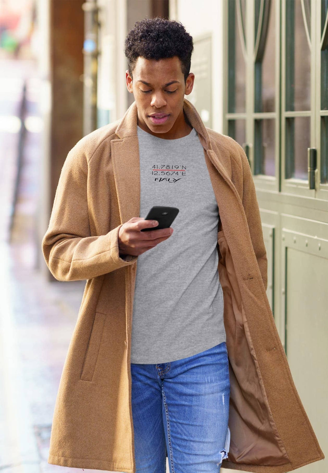 In his gray tee, he walks, checking his cellphone, moments of technology enhancing his journey with efficiency and connection.