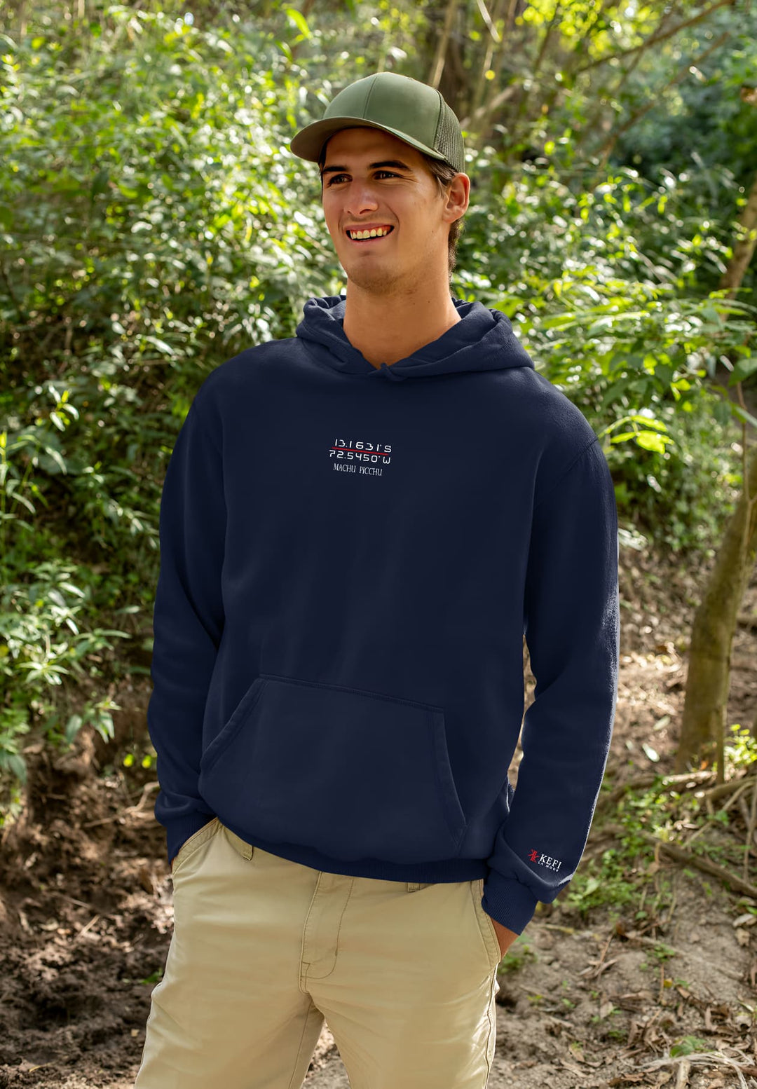 A joyful man strolling through the trees while wearing a blue hoodie.