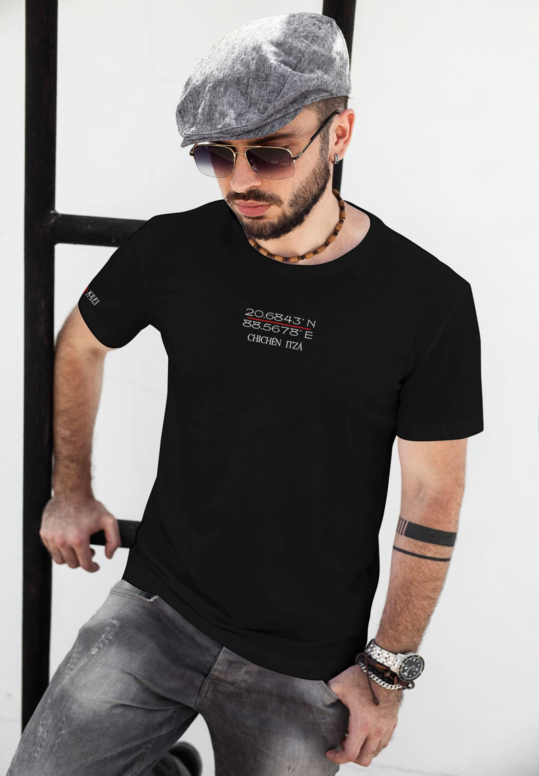 Embracing ancient mysteries, a man wears a black tee bearing Chichen Itza's coordinates, embodying the fusion of past and present.