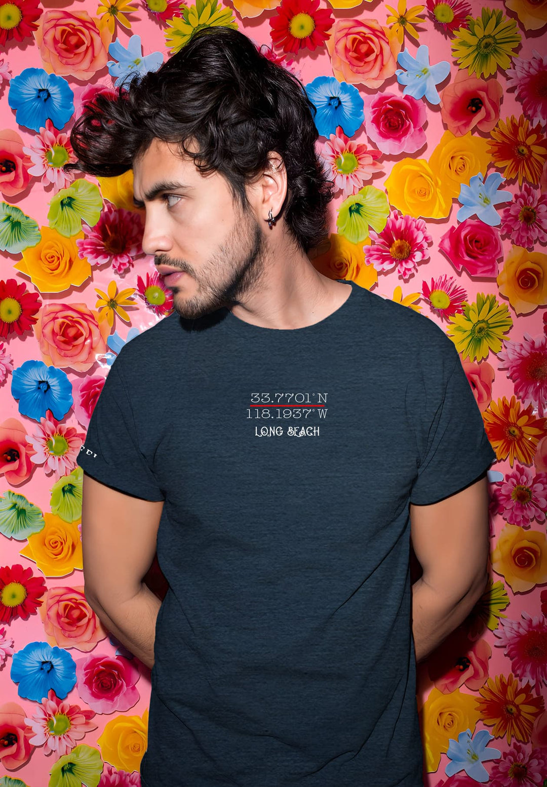 A blue t-shirt framed him against a flower wall, emotions intertwined with the blossoms, a living tapestry of feelings.