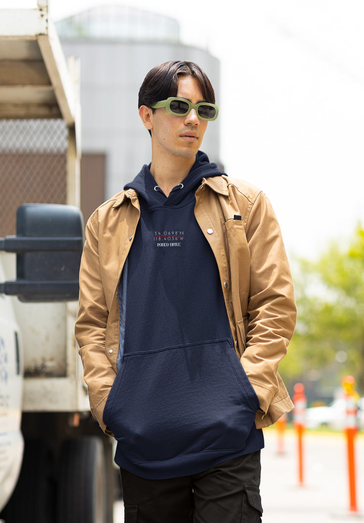 He poses in a blue hoodie with Rodeo Drive coordinates, blending street style and luxury.