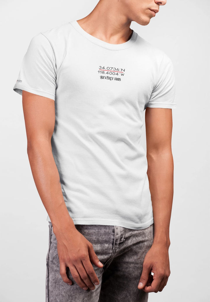 A man, effortlessly cool, rocks a white tee and denim jeans, capturing timeless style within the creative confines of a photo studio.