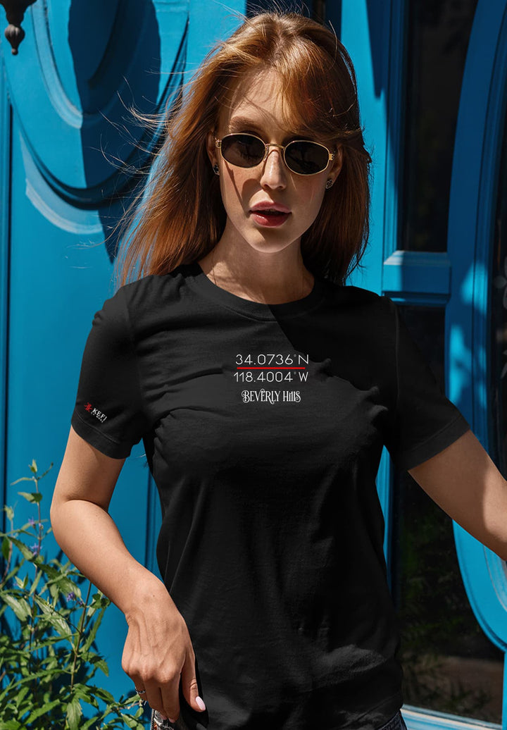 A woman in a black logo shirt and sunglasses stands outdoors, creating a memory  of cool confidence and understated elegance.