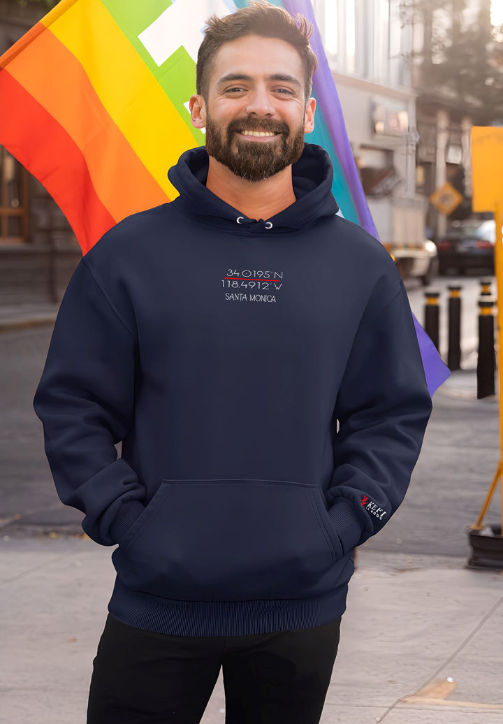 Style and geography intertwine as the man embraces the streets in a blue Kefi La Mode hoodie, spotlighting Santa Monica's GPS coordinates.