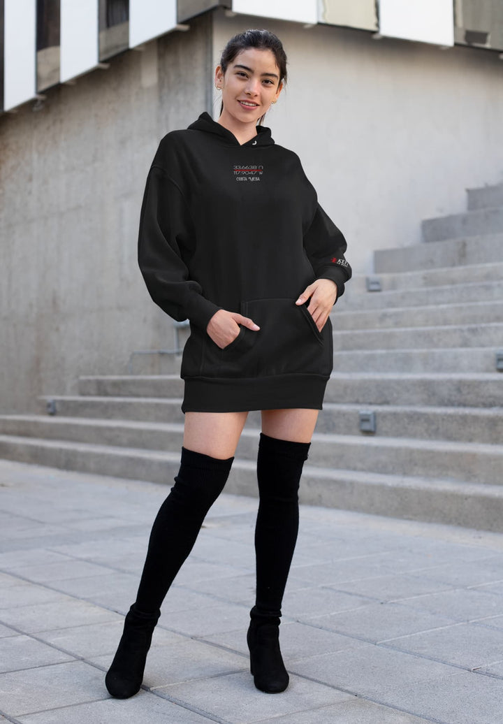 Amidst the backdrop of South Coast Plaza, a smiling woman in a xxl pullover black hoodie creates a serene fashion tableau.