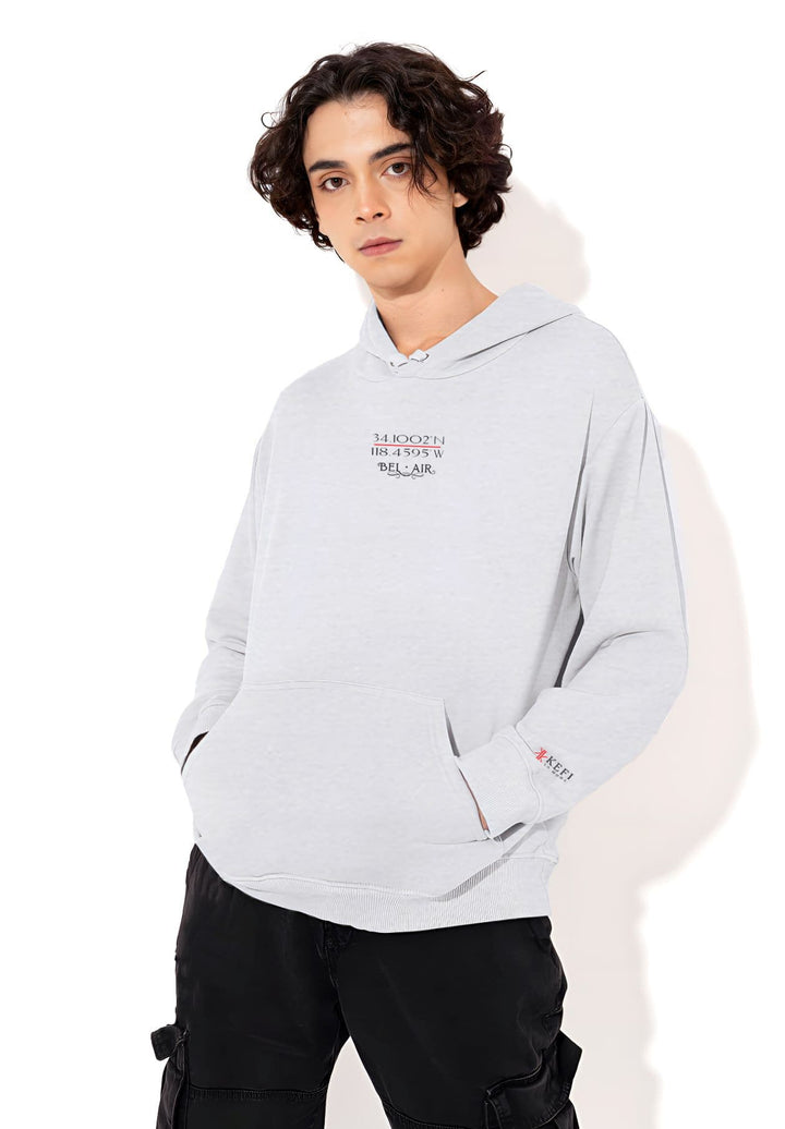The gray hoodie transforms into a narrative of self-expression as the stylish man brings location-inspired fashion to life with every step.