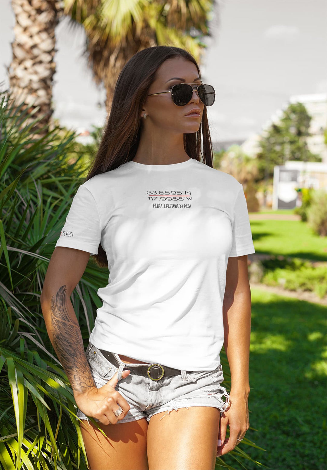 An edgy and stylish tattooed woman confidently struts in a white T-shirt, embodying a unique blend of fashion and individuality.