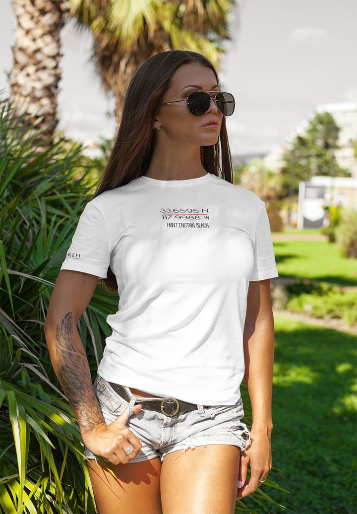 An edgy and stylish tattooed woman confidently struts in a white T-shirt, embodying a unique blend of fashion and individuality.