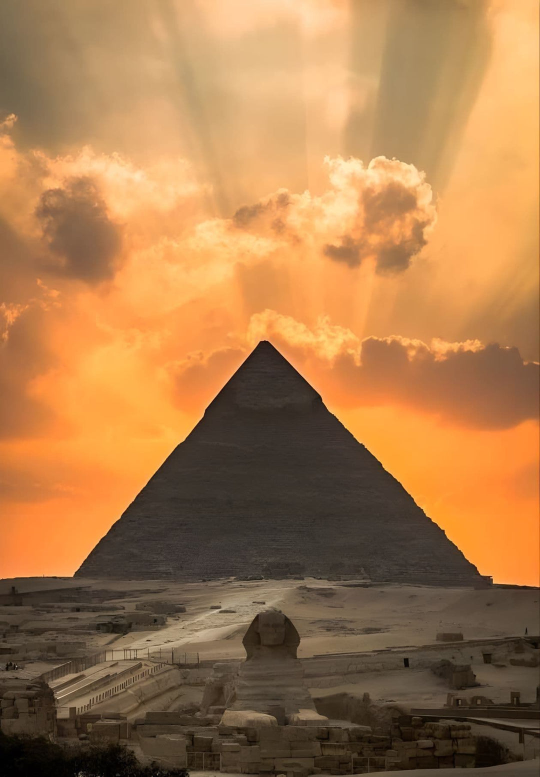 The Pyramid of Giza and the Sphinx in Egypt are illuminated by the setting sun.