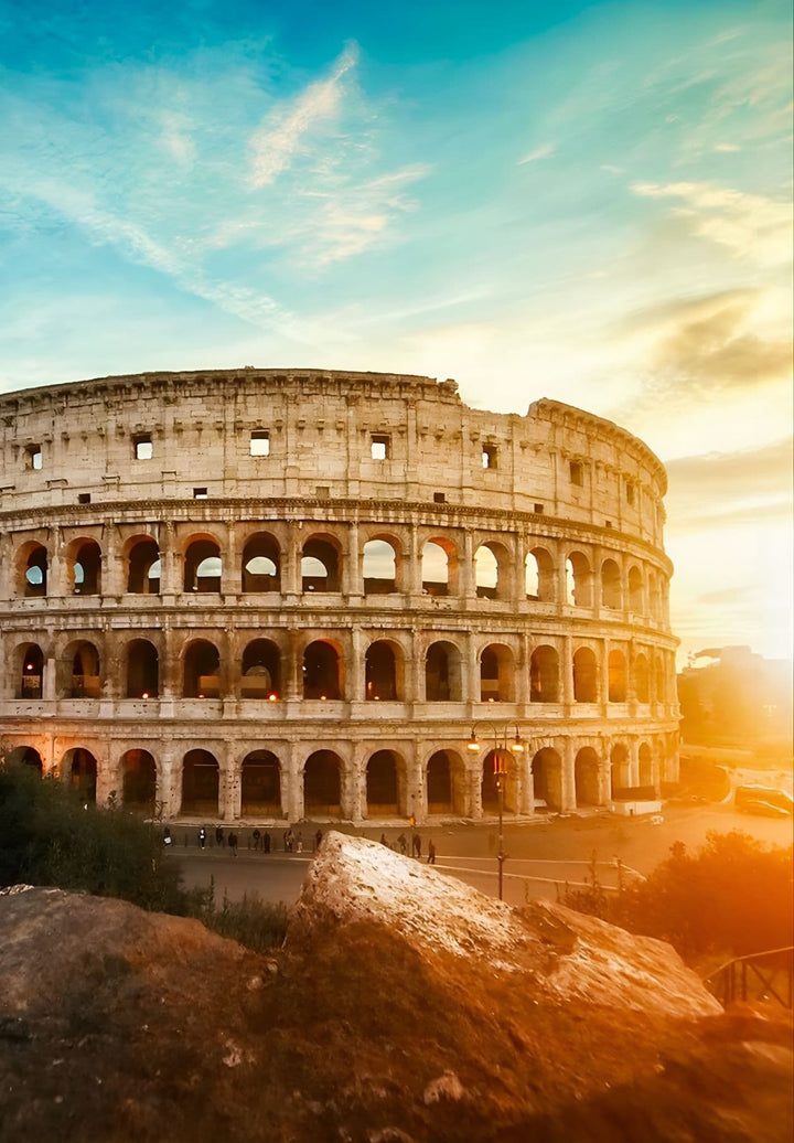As the sun bids adieu, the Roman Colosseum bathes in a warm, golden glow, embracing the day's end with timeless magnificence.