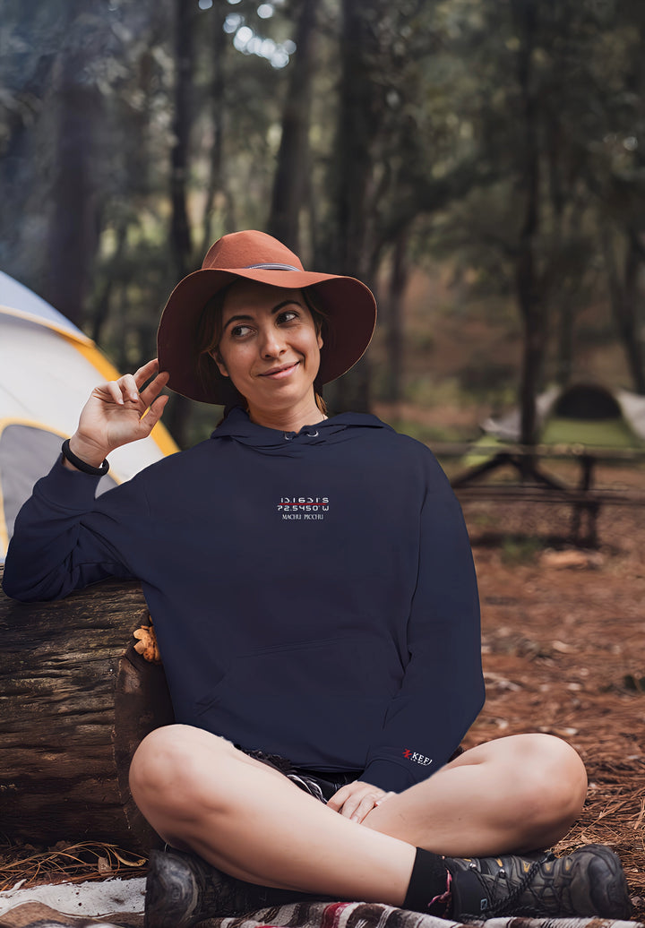 The woman enjoys the campground in her blue Machu Picchu pullover hoodie, fashioning a moment that embodies a blend of comfort, cultural admiration, and outdoor serenity.