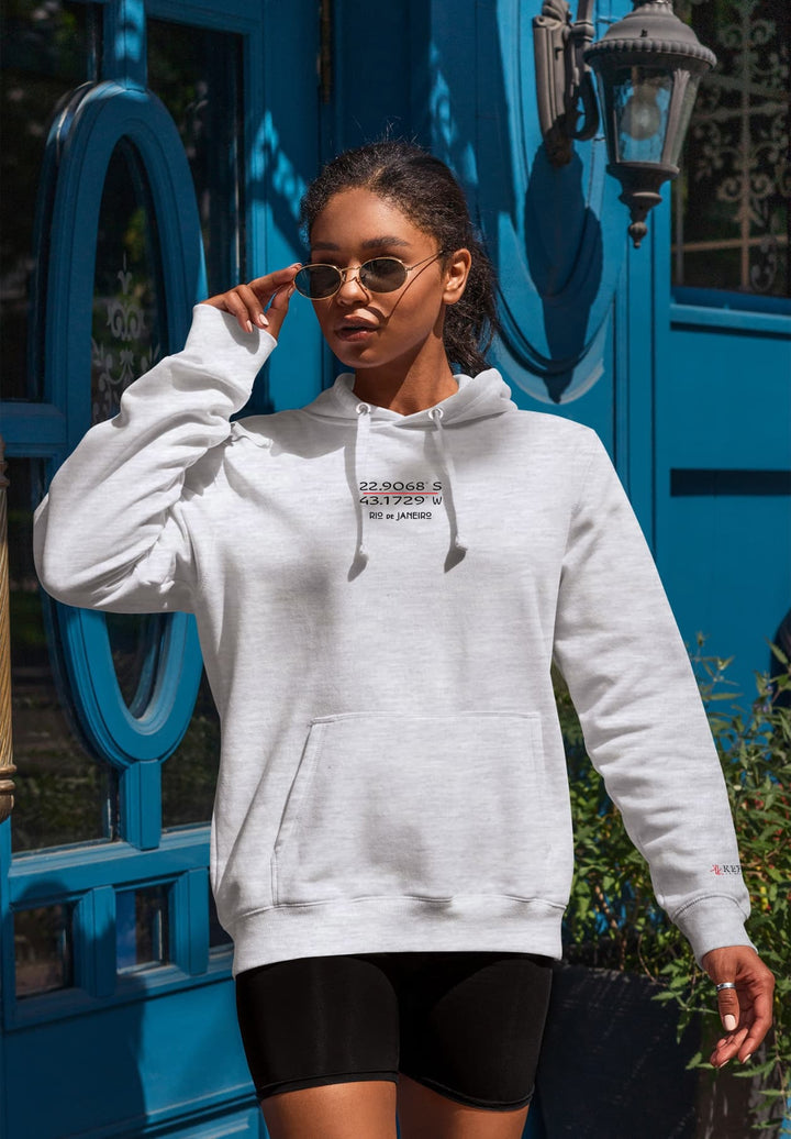 A woman in a gray hoodie stands out against a bright blue door, creating a fashion moment.